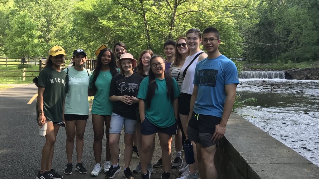 Group of Honors College students standing in from of a waterfall at Rock Creek Park