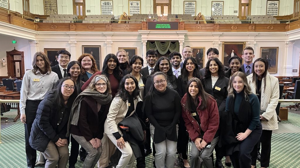 Group of Honors College students posing in the well of the Texas State Senate in Austin